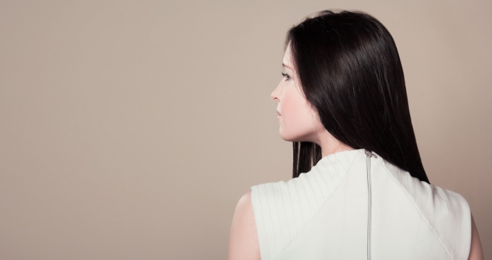 Woman in White Sleeveless High Neck Top Showing Her Back