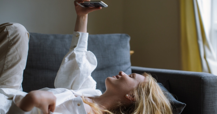 Woman in White Dress Shirt Holding a Smartphone