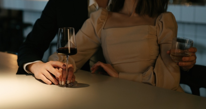 Woman in Beige Long Sleeve Shirt Holding Wine Glass