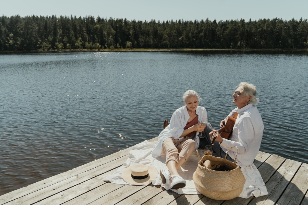 Man and Woman Sitting on Brown Wooden Dock