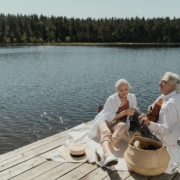 Man and Woman Sitting on Brown Wooden Dock