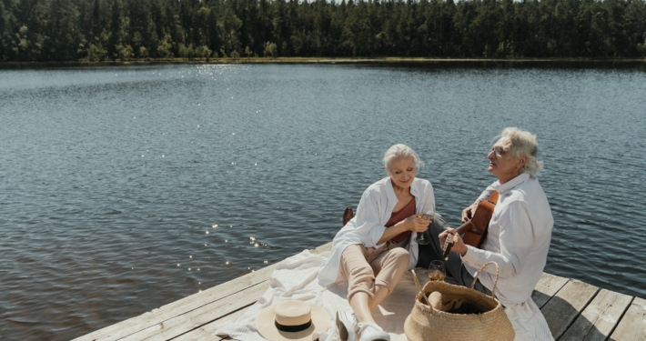 Man and Woman Sitting on Brown Wooden Dock