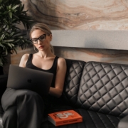 woman in black tank top wearing sunglasses sitting on black leather couch