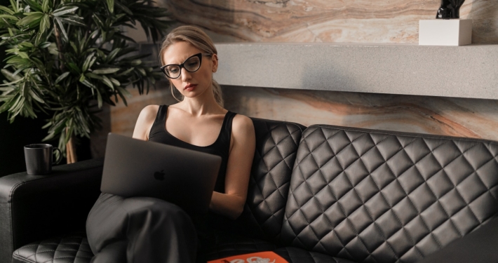 woman in black tank top wearing sunglasses sitting on black leather couch