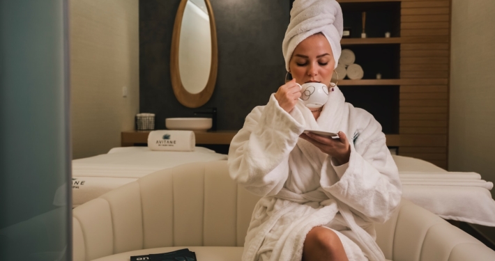 woman in white robe sitting on white couch