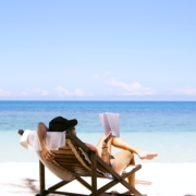 woman sits on brown wooden beach chair