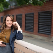 woman in black long sleeve shirt sitting on brown wooden bench