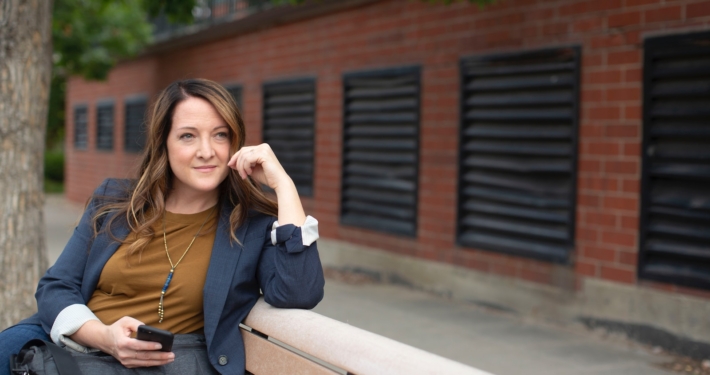 woman in black long sleeve shirt sitting on brown wooden bench