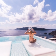 woman sitting on white chair near body of water during daytime