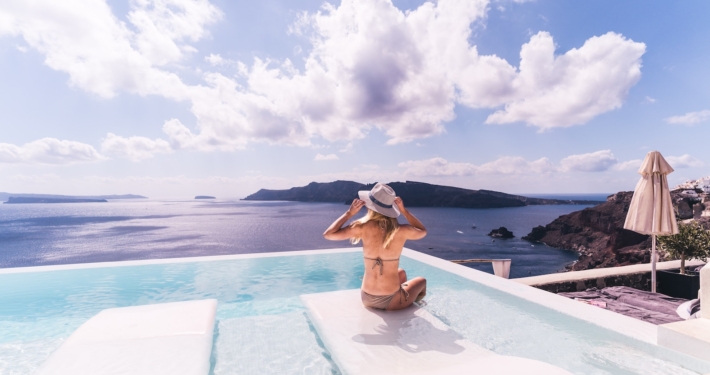 woman sitting on white chair near body of water during daytime