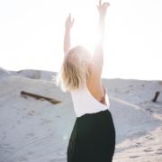 woman standing on the desert while her hands up