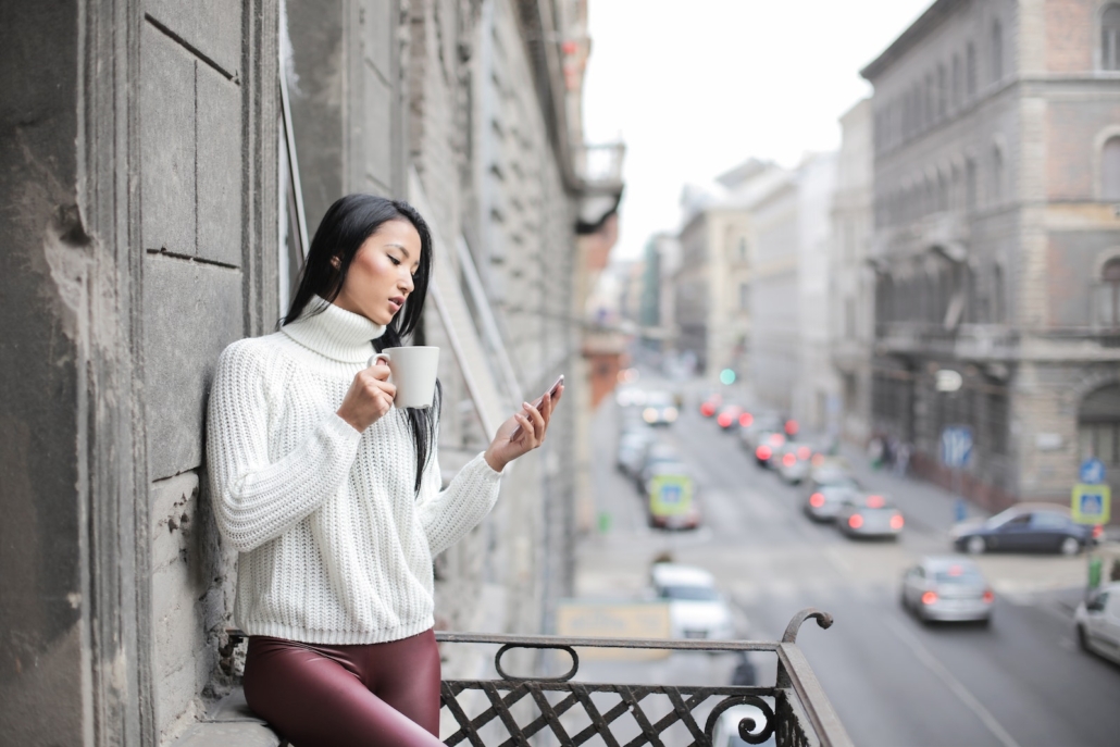 Woman in White Sweater Holding A White Ceramic Cup