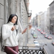 Woman in White Sweater Holding A White Ceramic Cup