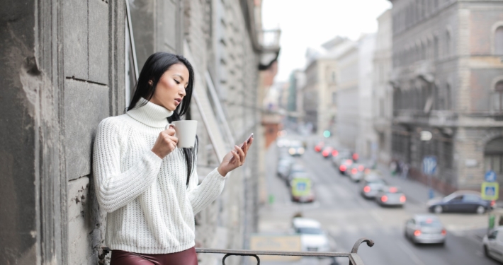 Woman in White Sweater Holding A White Ceramic Cup