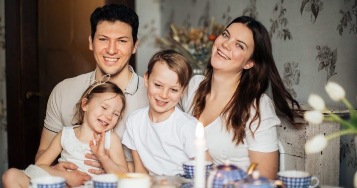 Loving family laughing at table having cozy meal