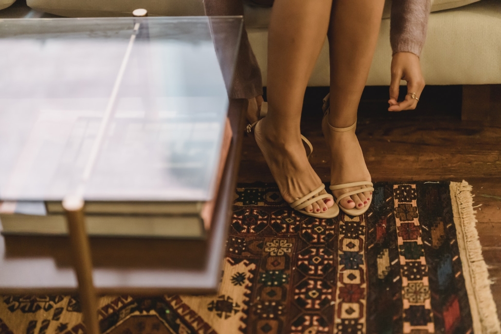 Woman in sandals on heels in lounge with rug