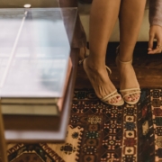 Woman in sandals on heels in lounge with rug