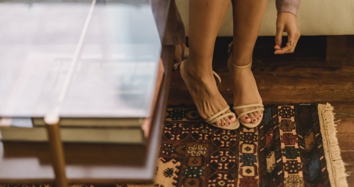 Woman in sandals on heels in lounge with rug