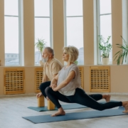 Elderly Man and Woman Doing Leg Stretching Exercise on Yoga Mat