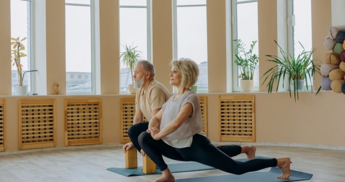 Elderly Man and Woman Doing Leg Stretching Exercise on Yoga Mat