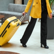 Person in Yellow Coat Pulling a Suitcase