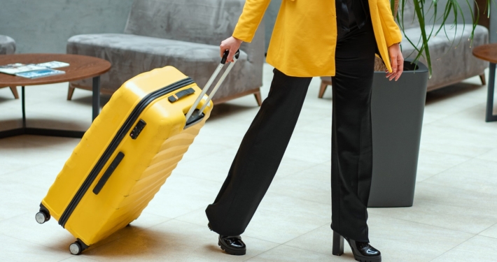 Person in Yellow Coat Pulling a Suitcase