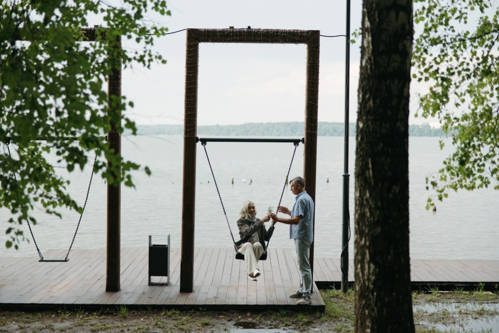 Elderly Woman riding a Swing with her Husband holding the Rope