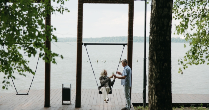 Elderly Woman riding a Swing with her Husband holding the Rope