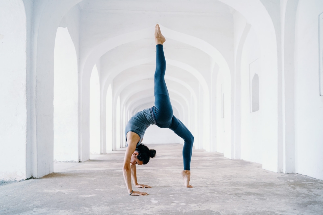 woman in blue leggings and black tank top doing yoga