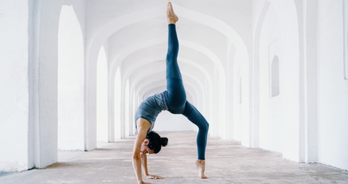 woman in blue leggings and black tank top doing yoga