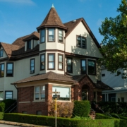 brown and white concrete house near green trees under blue sky during daytime