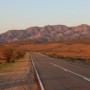 gray concrete road near brown mountains during daytime