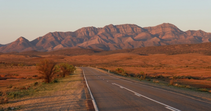 gray concrete road near brown mountains during daytime