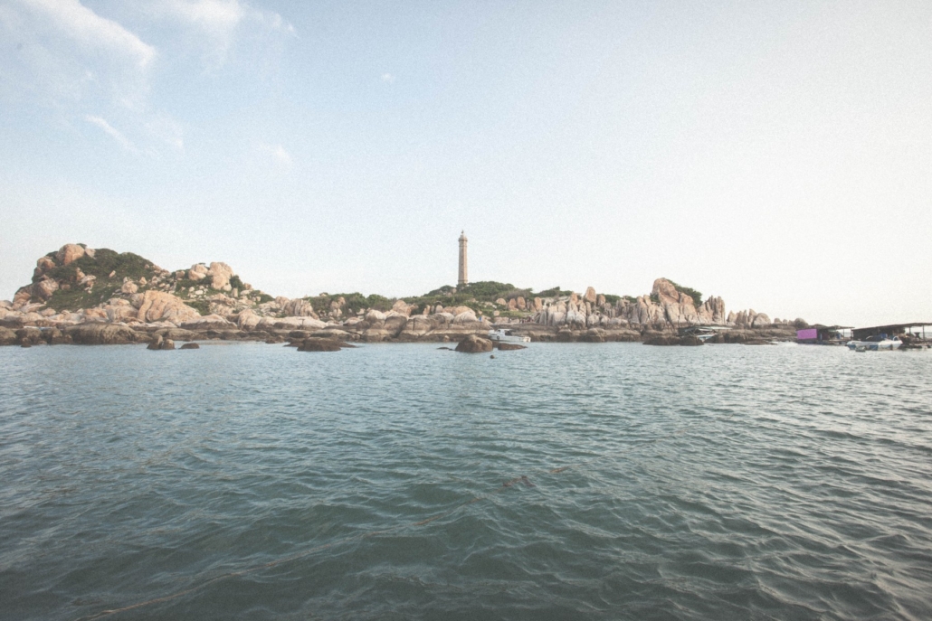 Calm water and boulder-strewn shores around the lighthouse island at Ke Ga.