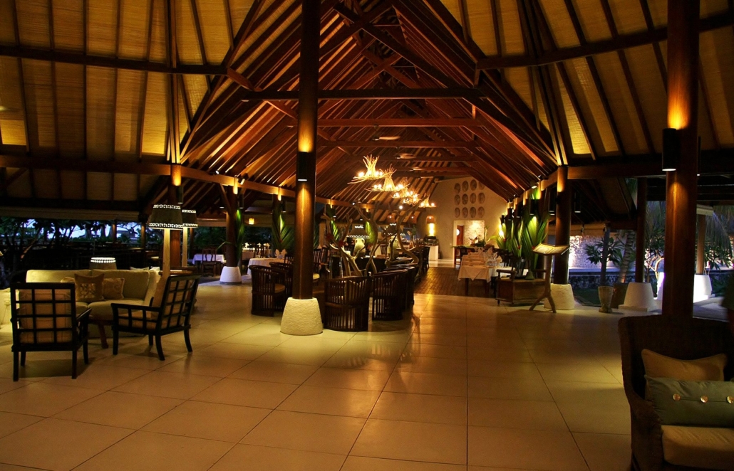 Thatched resort centre at Denis Private Island at dusk.