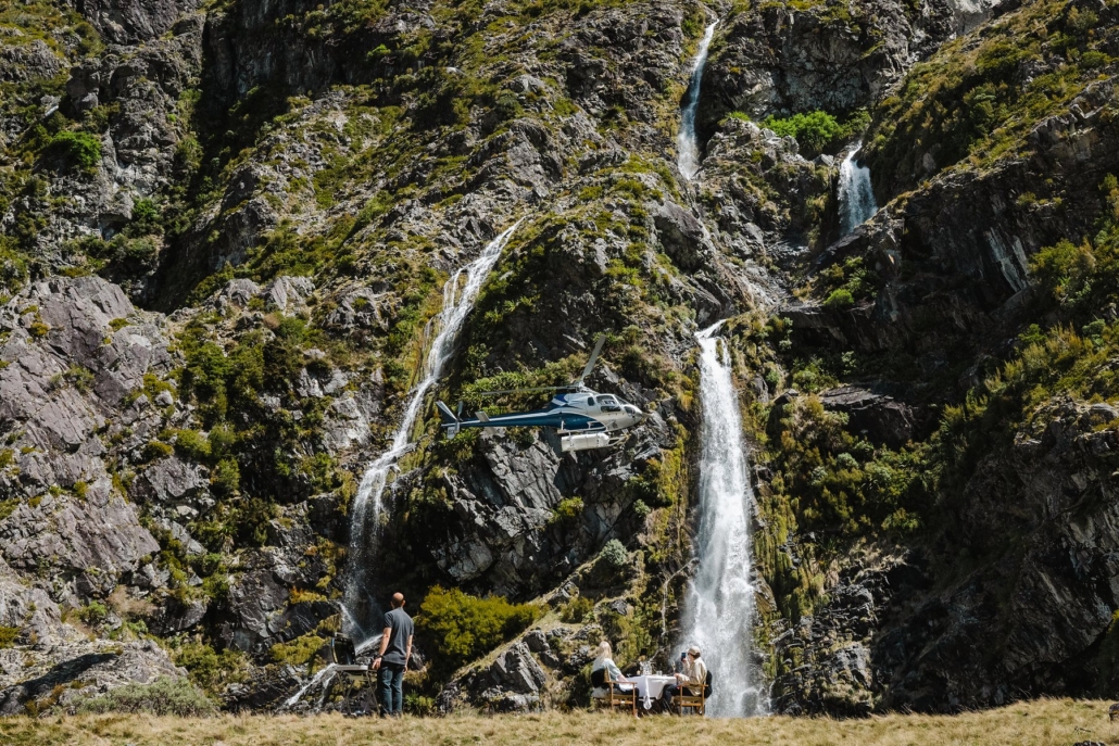 A helicopter beside a waterfall on a Lindis heli excursion.