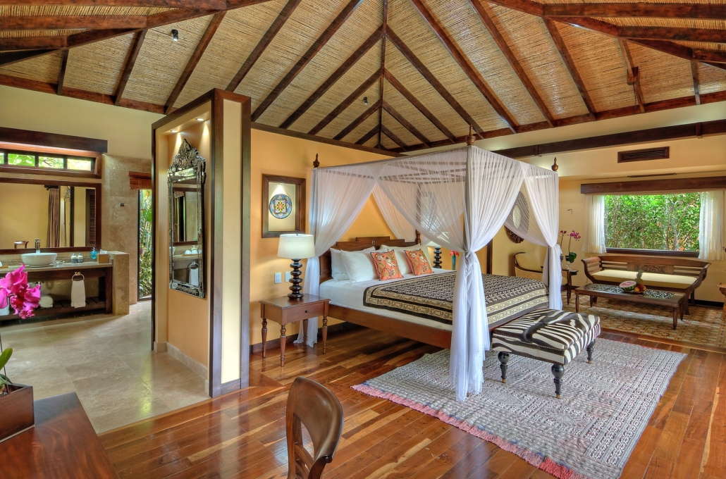 A villa bedroom at Nayara Springs, with a canopy bed and rainforest views.