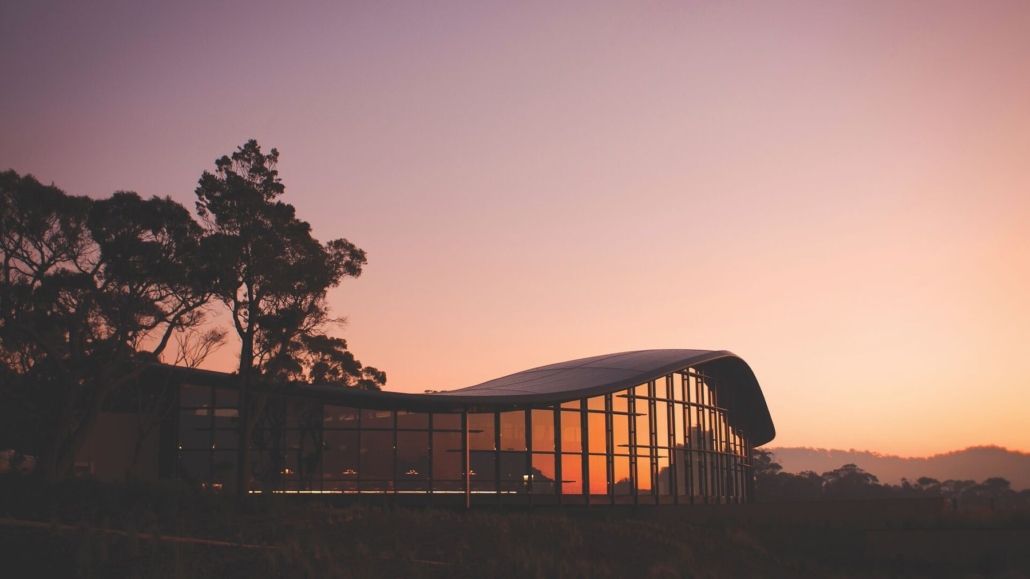 The lodge's sweeping roofline against a rose-coloured dawn.